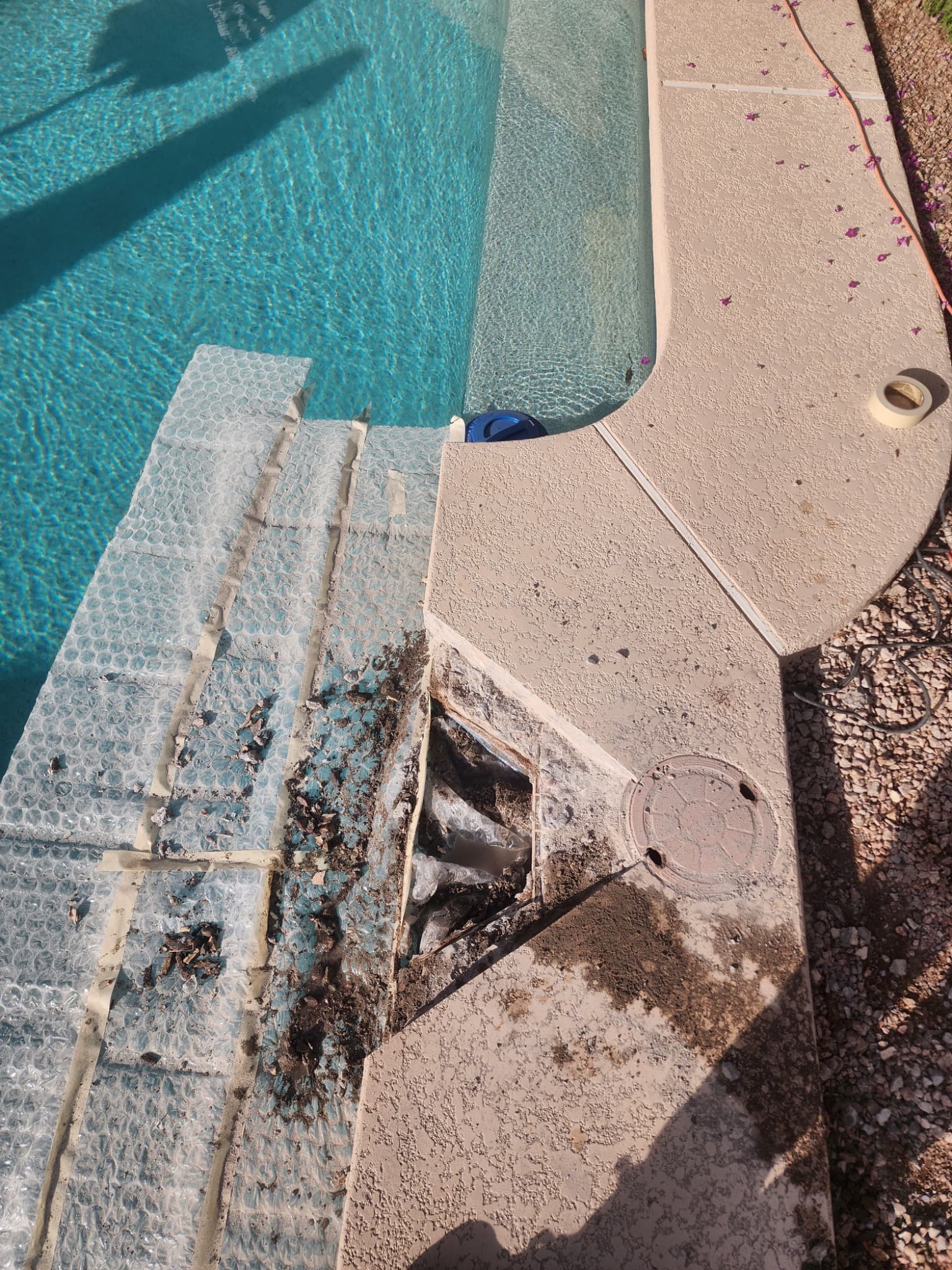 Damaged concrete surrounding a swimming pool skimmer